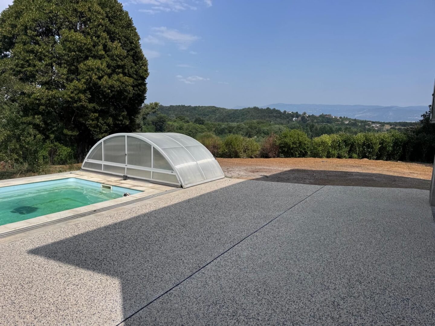 Terrasse en béton désactivé autour d'une piscine à Saint-Lattier